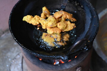 Onion pakora frying in iron pen. This is a popular street food in Indian subcontinent. Onion which...