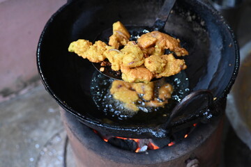Onion pakora frying in iron pen. This is a popular street food in Indian subcontinent. Onion which...