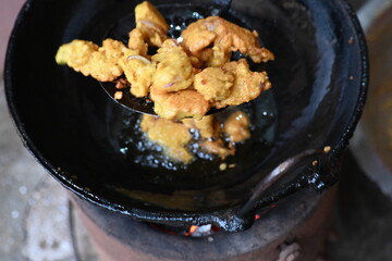 Onion pakora frying in iron pen. This is a popular street food in Indian subcontinent. Onion which...