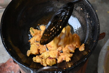 Onion pakora frying in iron pen. This is a popular street food in Indian subcontinent. Onion which...
