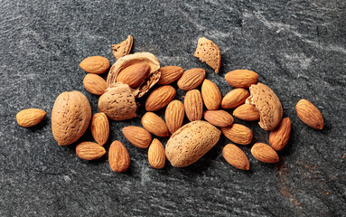 Almonds on a black stone background.