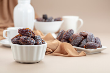 Dates in white dish on a beige background.