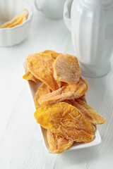 Dried mango slices on a white table.