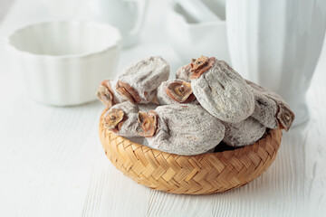 Dried persimmons on a white wooden table.