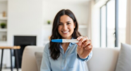 A delighted woman displays a positive pregnancy test, celebrating her exciting news.