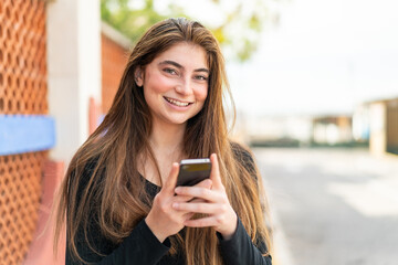 Young pretty caucasian woman sending a message with the mobile