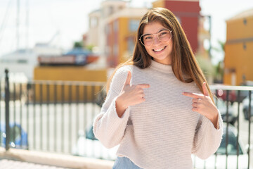 Young pretty caucasian woman with glasses at outdoors proud and self-satisfied