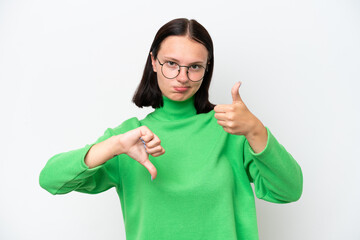 Young caucasian woman isolated on white background making good-bad sign. Undecided between yes or...