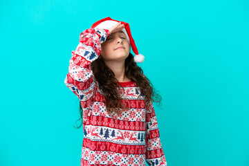Little caucasian with christmas hat isolated on blue background has realized something and...