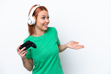Young Russian girl playing with a video game controller isolated on white background with surprise...