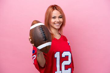 Young Russian girl playing rugby isolated on pink background with happy expression