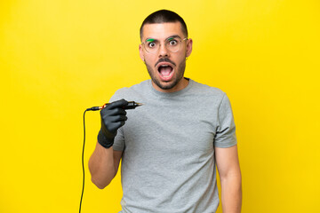Tattoo artist caucasian man isolated on yellow background with surprise facial expression