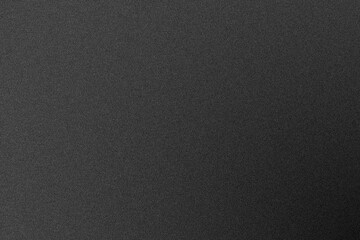 Close up of a dark grey textured fabric surface with a subtle grainy pattern providing a neutral background