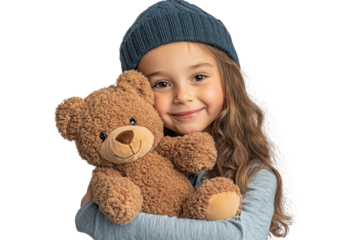 Happy little girl hugging a soft teddy bear while wearing a cozy beanie indoors during a playful winter day