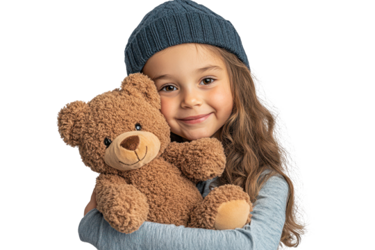 Happy little girl hugging a soft teddy bear while wearing a cozy beanie indoors during a playful winter day