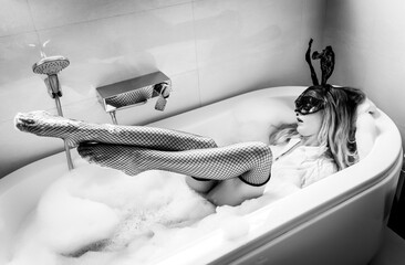 Sexy nude young woman with black mask posing in the bathroom