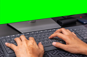 Developer coding at a modern workstation with a green screen monitor background. Ideal for tech ads, software development, digital content creation, chroma key projects.