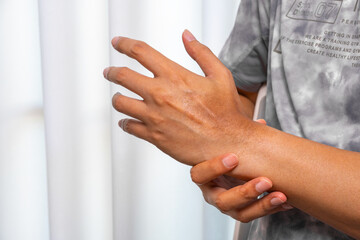 Man supporting their aching wrist under a warm therapy lamp, showing visible tendon stress and bone alignment focus. Perfect for wrist pain relief, brace therapy, and tendon injury ads.