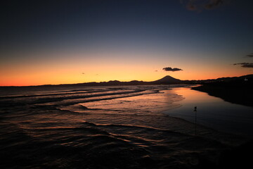 穏やかな波が打ち寄せる海岸、夕陽が染める鵠沼海岸　夕景