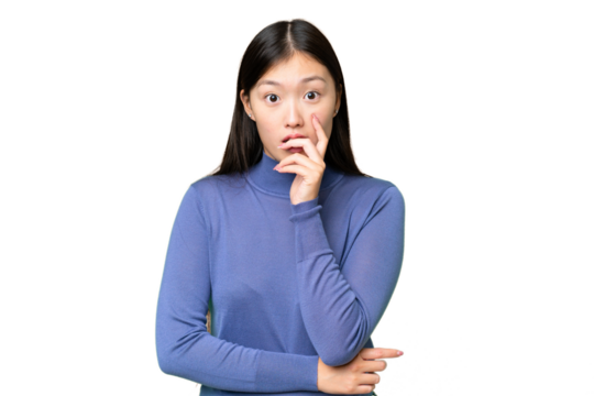 Young Asian woman over isolated chroma key background surprised and shocked while looking right