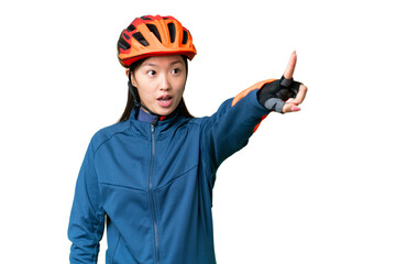 Young cyclist woman over isolated chroma key background pointing away