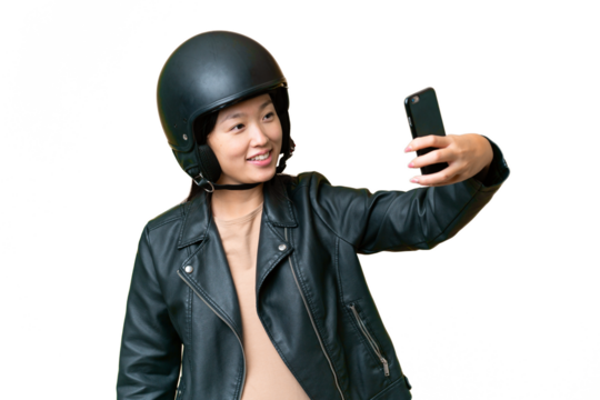 Young Asian woman with a motorcycle helmet over isolated chroma key background making a selfie