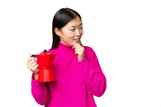 Young Asian woman holding coffee pot over isolated chroma key background thinking an idea and looking side - Powered by Adobe