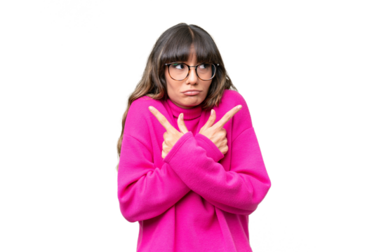 Young caucasian woman over isolated background pointing to the laterals having doubts