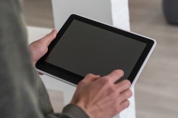 Digital tablet computer with isolated screen in male hands over cafe background