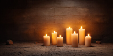 Softly glowing candles arranged on a rustic surface, casting warm light against a dark background, creating a serene and tranquil atmosphere.