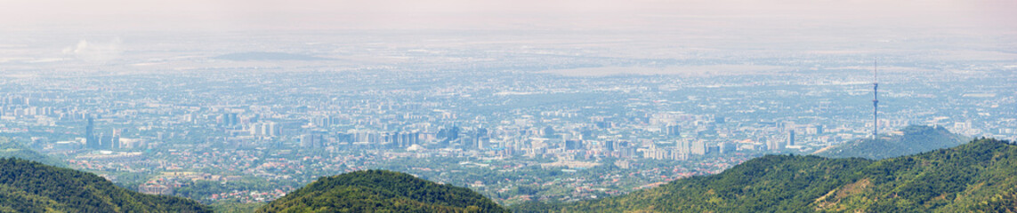 Urban skyline of Almaty, Kazakhstan, seen from the surrounding mountains, highlighting the Kok Tobe TV Tower and vast cityscape