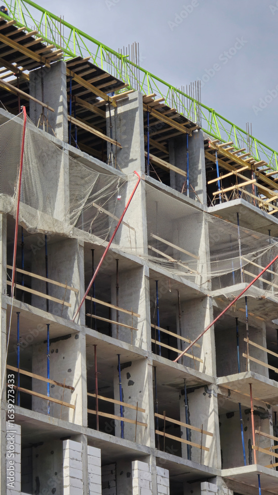 Poster building under construction with safety netting and scaffolding
