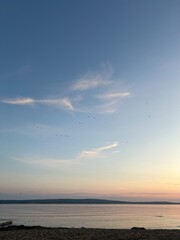 Peaceful sunset over the sea with soft clouds and calm water