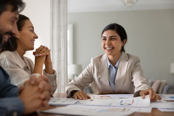 Indian woman advisor and married couple, exploring loan options, reviewing rates, loan terms...