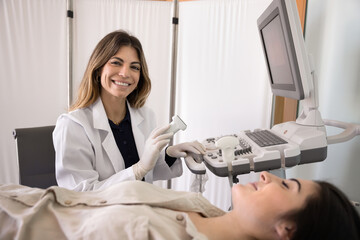 Portrait of positive ultrasound diagnosis technician doctor wearing white lab coat, working at...