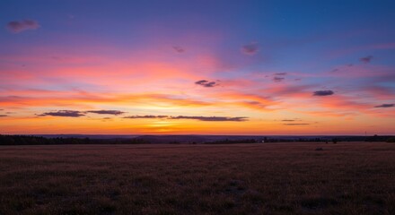 Fototapeta premium Sunset over a vast meadow with colorful sky