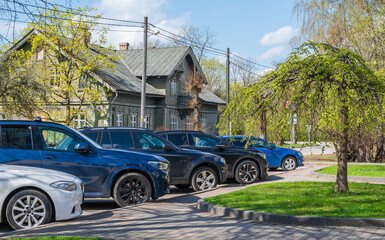 A group of cars on the street in a parking lot.
