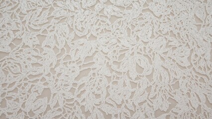 Ivory lace textile displayed against a plain backdrop