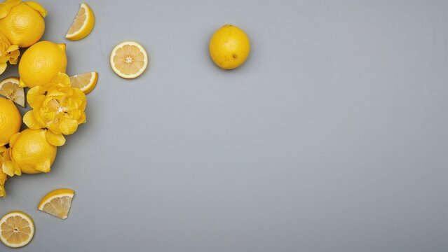 Fresh lemon blossoms thriving against a plain gray backdrop, leaving space for text overhead.