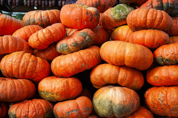 A pile of vibrant orange pumpkins at a local market, showcasing natural texture and rustic charm, perfect for autumn, Halloween, farming, or seasonal food themes. Natural beta carotene, healthy food