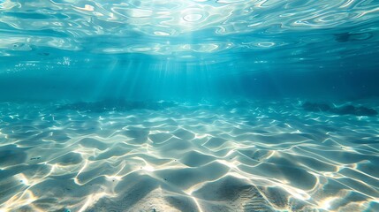 Fototapeta premium Sunlight filtering through clear turquoise water illuminating a sandy ocean floor