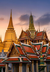 Fototapeta premium Golden Grand Palace in Bangkok, Thailand: Majestic gilded spires and ornate roofs of the Grand Palace in Bangkok, Thailand, illuminated by a sunset.