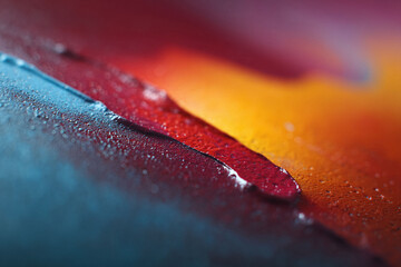 Abstract macro shot featuring vibrant, wet, textured surfaces of blue, red, and orange. Evokes coolness and warmth, creating visual interest. Use for backgrounds, designs, or concepts.