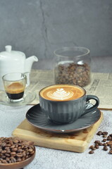 Cup of hot cappuccino coffee with beautiful latte art in a beautiful glass on the table