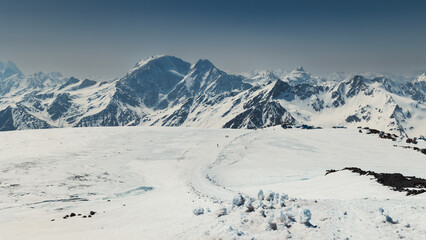Snow covered plateau with panoramic view to Great Caucasian Ridge on sunny day, Terskol, Russia