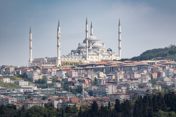 Cityscape with big mosque and six minarets on hilltop above city on sunny day, Istanbul, Turkey