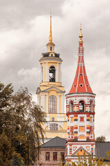 Colorful ancient Russian church and bell tower close up on cloudy day, Suzdal, Russia