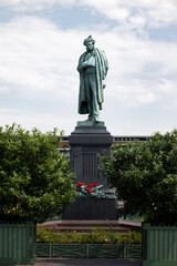 Monument to Russian poet Alexander Pushkin surrounded by trees on summer sunny day, Moscow, Russia