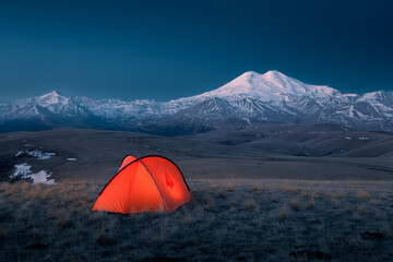 Night landscape with red bright tent mountain ridge snow-covered Mount Elbrus, Caucasus, Russia