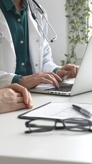 Doctor man wearing lab coat over a green shirt, is typing on a laptop and listening to a woman patient during medical consultation in clinic. Medicine and health care